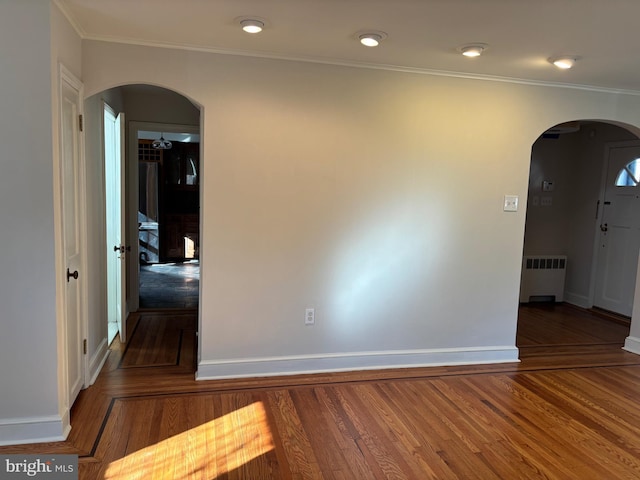 unfurnished room with dark hardwood / wood-style floors, ornamental molding, and radiator