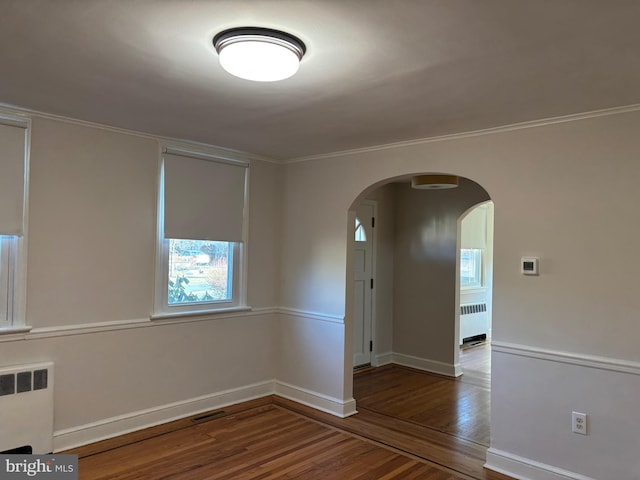 spare room with radiator heating unit and hardwood / wood-style flooring