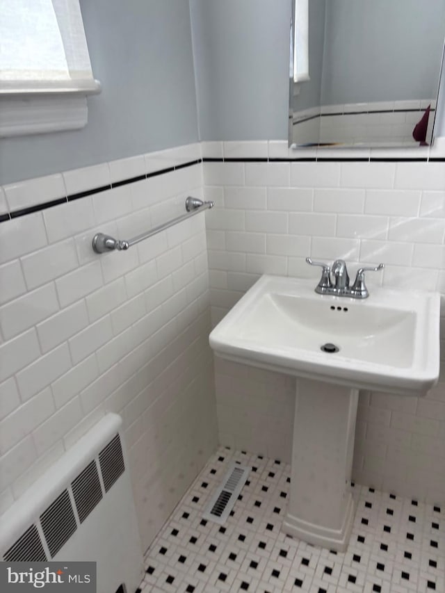 bathroom with tile patterned floors, tile walls, and sink