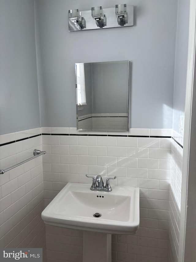 bathroom featuring sink and tile walls