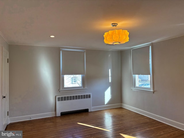 unfurnished room with dark wood-type flooring and radiator