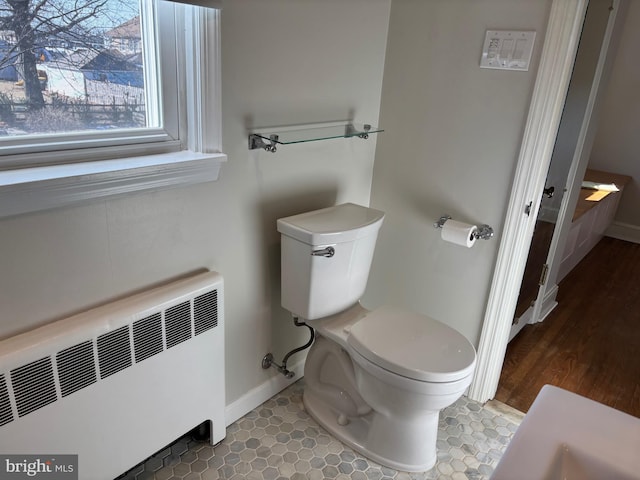 bathroom featuring tile patterned flooring, radiator heating unit, and toilet