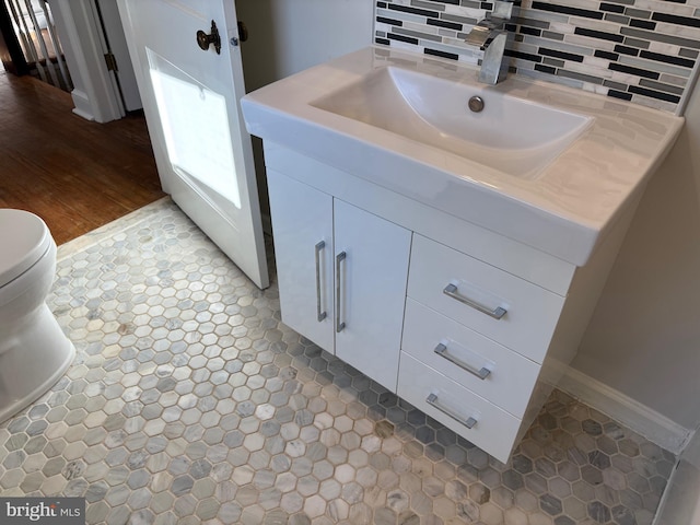 bathroom featuring decorative backsplash, vanity, and toilet