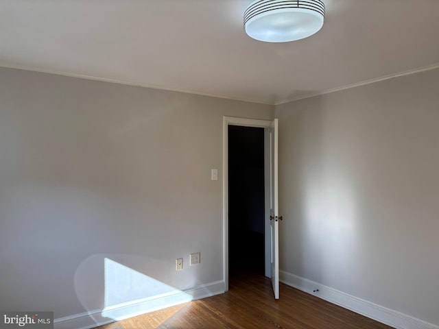 unfurnished room featuring dark hardwood / wood-style floors and crown molding