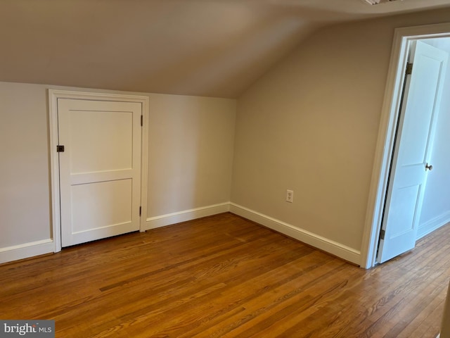 bonus room with light wood-type flooring and vaulted ceiling