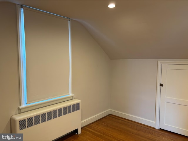 bonus room featuring radiator heating unit, hardwood / wood-style flooring, and vaulted ceiling