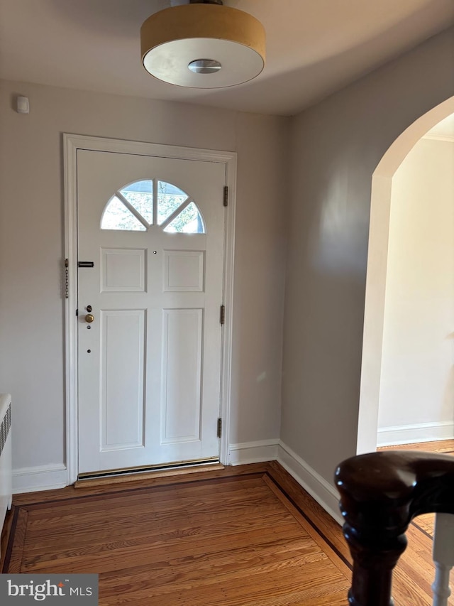 entryway with wood-type flooring and radiator heating unit