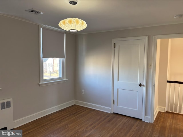 unfurnished room featuring radiator and dark hardwood / wood-style floors