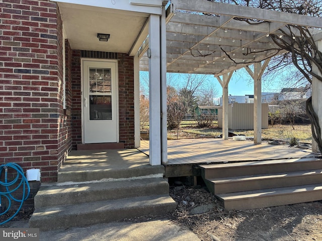 entrance to property featuring a deck and a pergola