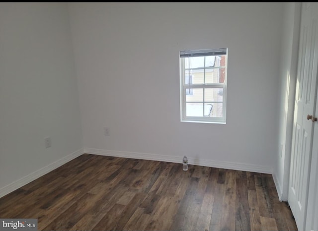 empty room with dark hardwood / wood-style flooring