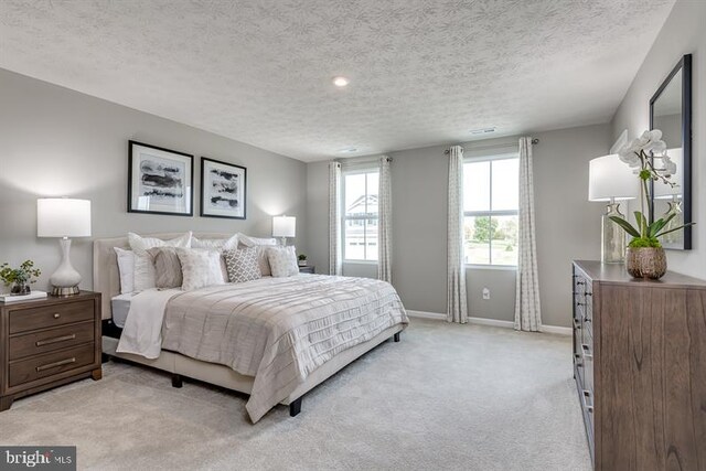 bedroom with light carpet and a textured ceiling