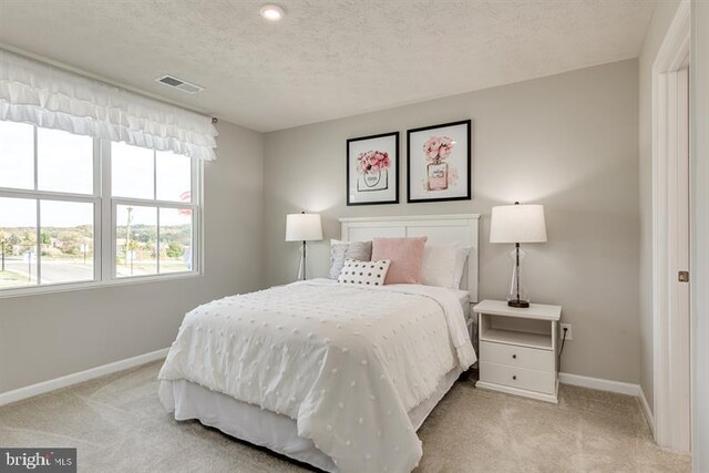 carpeted bedroom featuring a textured ceiling