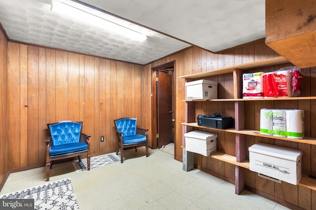 sitting room featuring a textured ceiling and wood walls