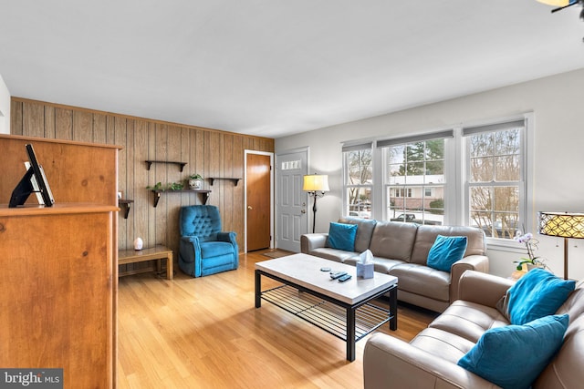 living room featuring wooden walls and light hardwood / wood-style floors