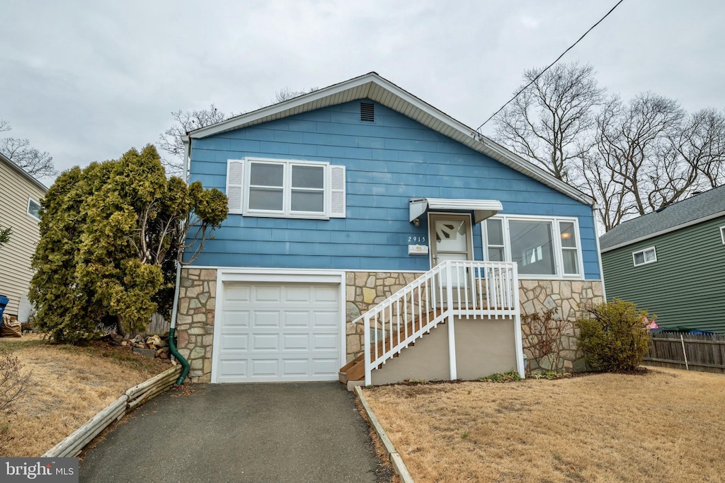 view of front of property with a front yard and a garage