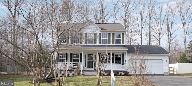 view of front of property featuring a front lawn, a porch, and a garage