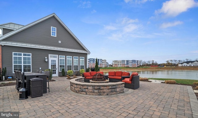 view of patio with an outdoor fire pit and a water view