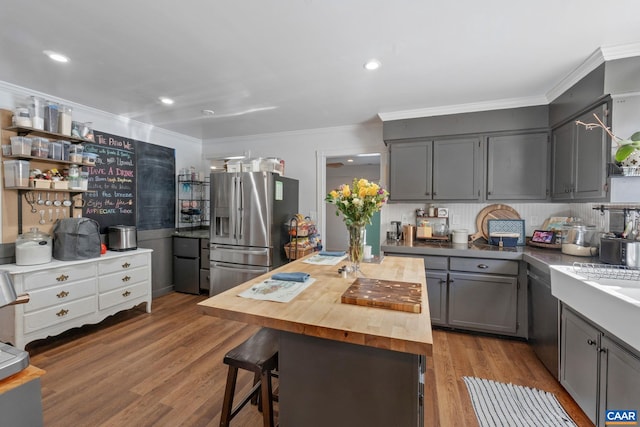 kitchen featuring wooden counters, backsplash, gray cabinetry, hardwood / wood-style flooring, and stainless steel fridge with ice dispenser