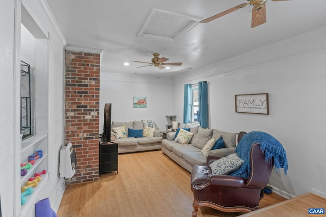 living room with wood-type flooring, ornamental molding, and heating unit