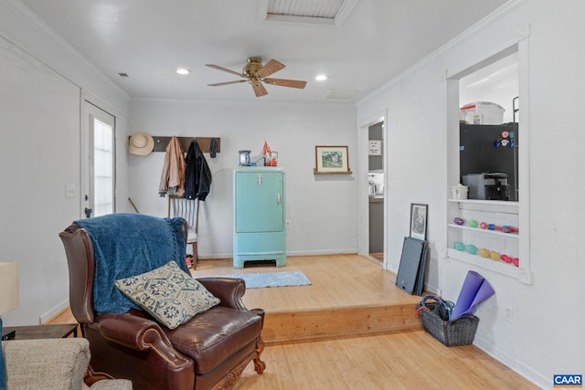 sitting room featuring hardwood / wood-style flooring, ceiling fan, and ornamental molding