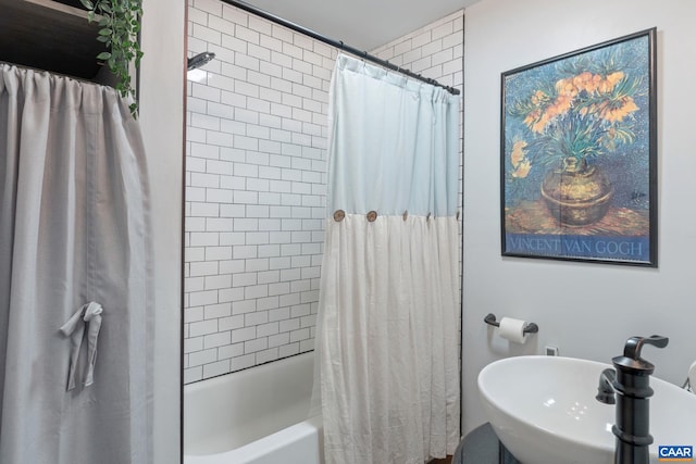 bathroom featuring shower / bath combo with shower curtain and sink