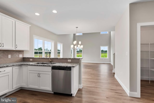 kitchen with sink, white cabinets, dishwasher, stone counters, and backsplash