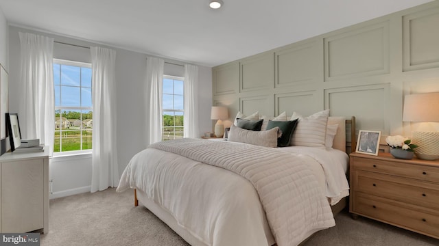 bedroom featuring multiple windows and light colored carpet