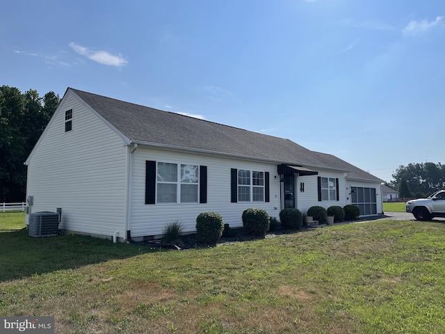 ranch-style house featuring cooling unit and a front yard