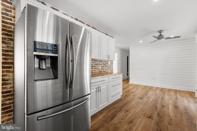 kitchen featuring ceiling fan, stainless steel fridge, light hardwood / wood-style floors, and white cabinetry