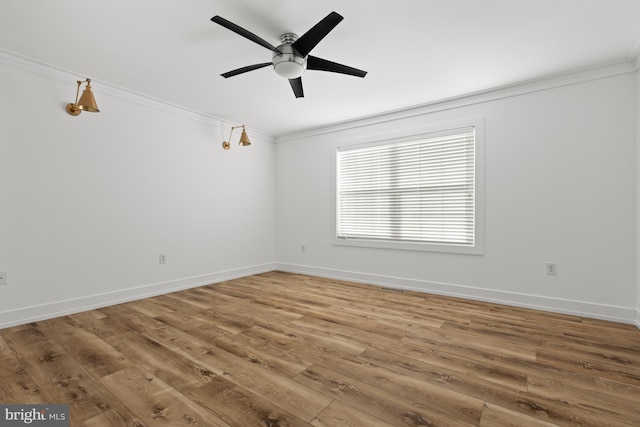 empty room with ceiling fan, crown molding, and hardwood / wood-style floors