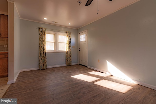 interior space featuring light wood-type flooring, ceiling fan, and ornamental molding