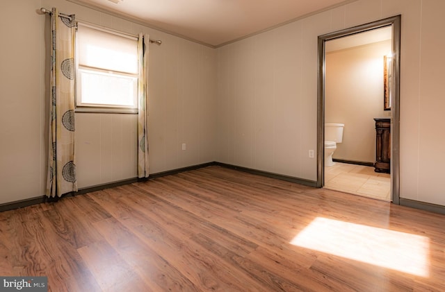 empty room featuring crown molding and light hardwood / wood-style floors