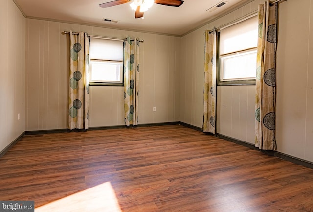 unfurnished room featuring ceiling fan, plenty of natural light, and dark wood-type flooring