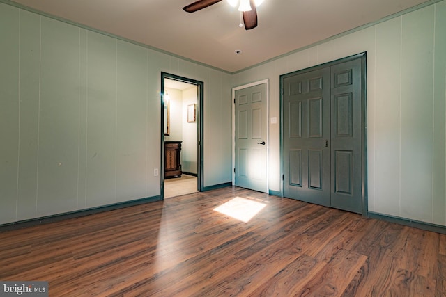 unfurnished bedroom featuring ensuite bath, ceiling fan, and hardwood / wood-style floors