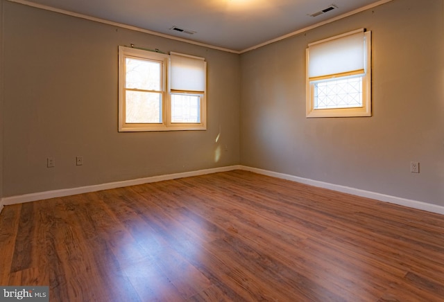 spare room featuring wood-type flooring and ornamental molding