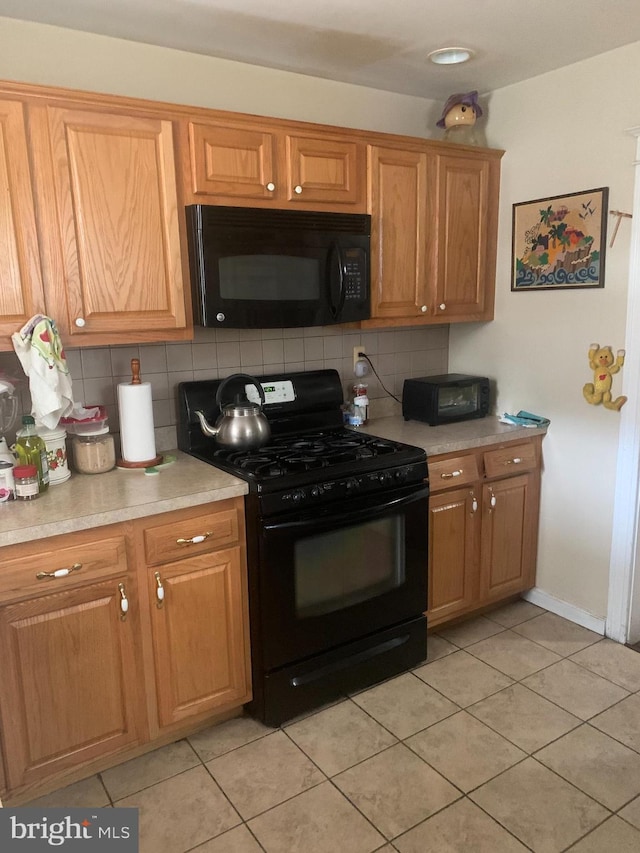 kitchen featuring light tile patterned flooring, tasteful backsplash, and black appliances