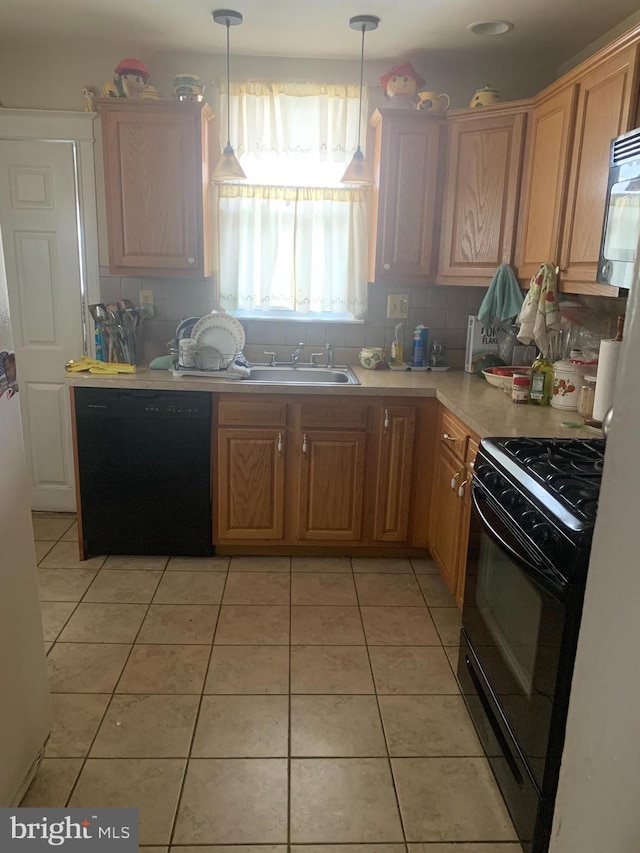 kitchen with hanging light fixtures, light tile patterned flooring, black appliances, and sink