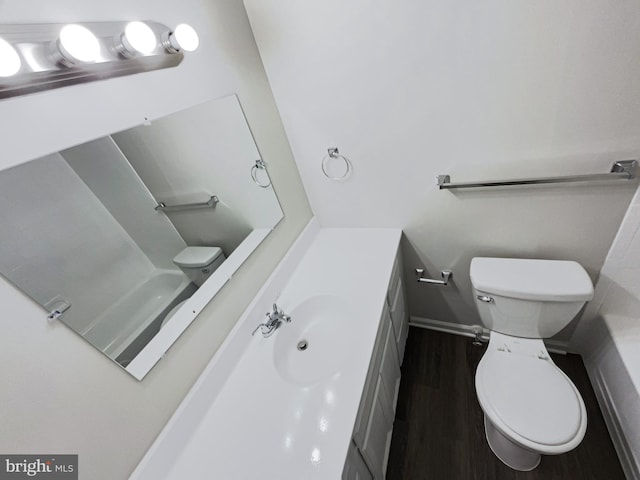 bathroom with hardwood / wood-style floors, vanity, and toilet