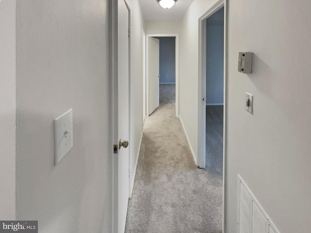 hall with light colored carpet