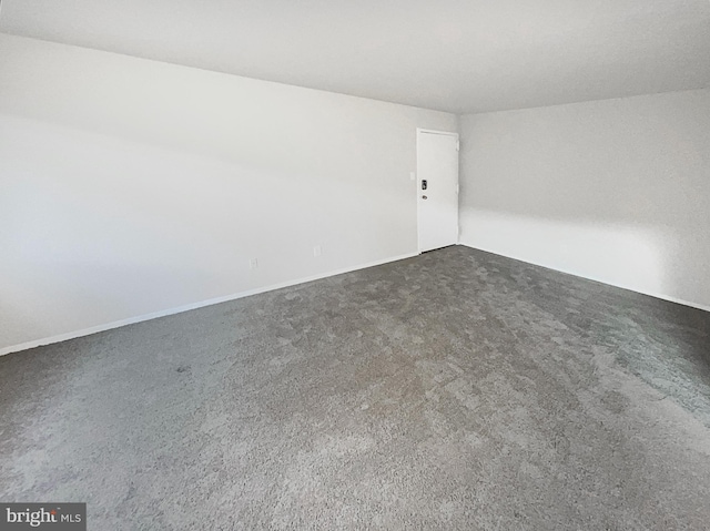 spare room with dark carpet