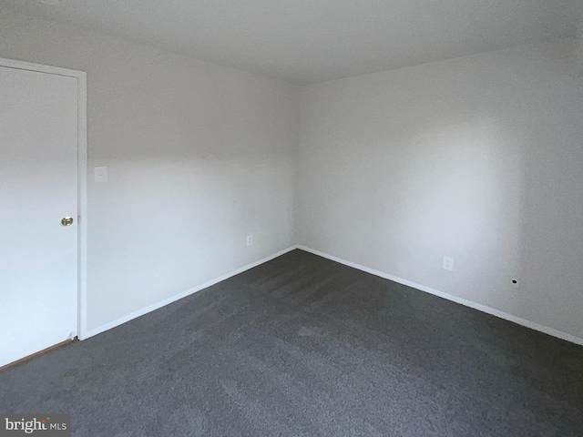 unfurnished room with dark carpet