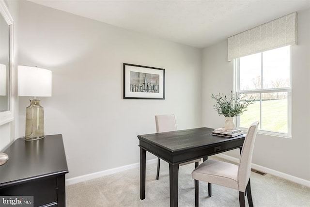 dining room featuring light colored carpet and plenty of natural light