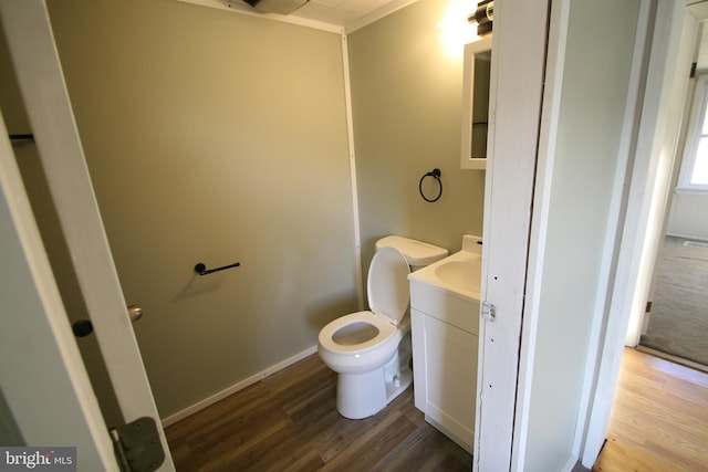 bathroom with hardwood / wood-style floors, vanity, toilet, and crown molding