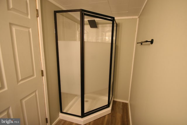 bathroom featuring crown molding, hardwood / wood-style floors, and walk in shower