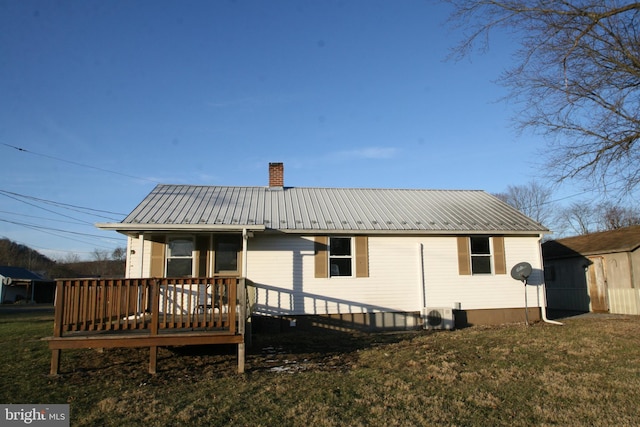 back of property featuring a wooden deck and a lawn