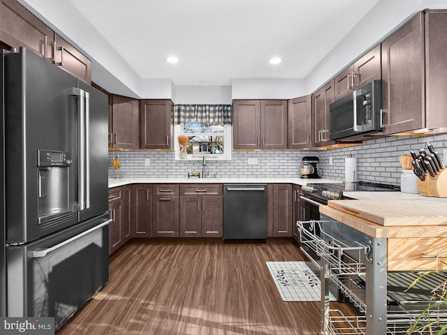 kitchen featuring backsplash, stainless steel appliances, and dark brown cabinetry