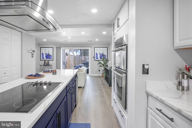 kitchen featuring white cabinetry, stainless steel double oven, blue cabinetry, black electric cooktop, and light stone counters