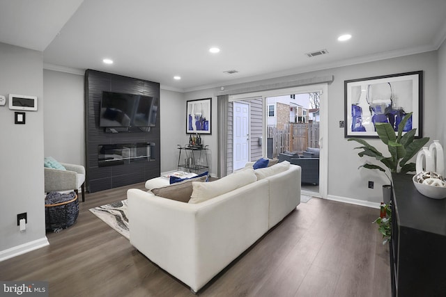 living room with a fireplace, dark hardwood / wood-style floors, and crown molding