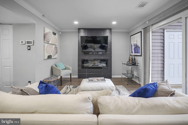 living room featuring hardwood / wood-style floors, ornamental molding, and a fireplace