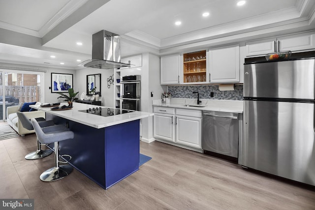 kitchen with appliances with stainless steel finishes, island range hood, white cabinets, and a kitchen island